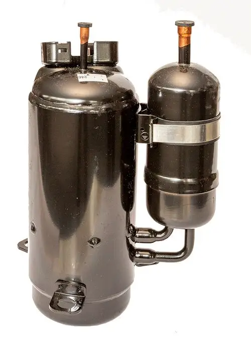 Schwarzer Kompressor von Daikin mit zwei zylindrischen Komponenten und mehreren Anschlüssen, zur Verwendung in Kühlsystemen.
